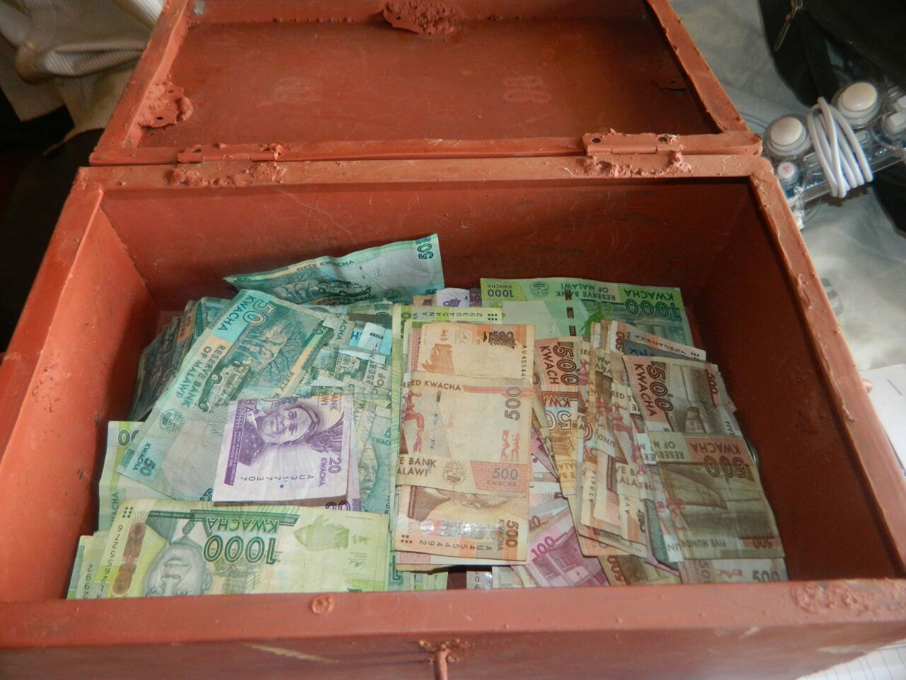 A red box full of money. This signifies the work done by the Village Savings Ministries at Namikango